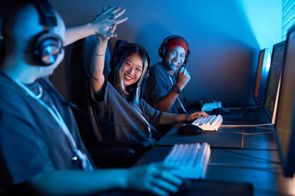 Image of gamers sitting at computers celebrating.