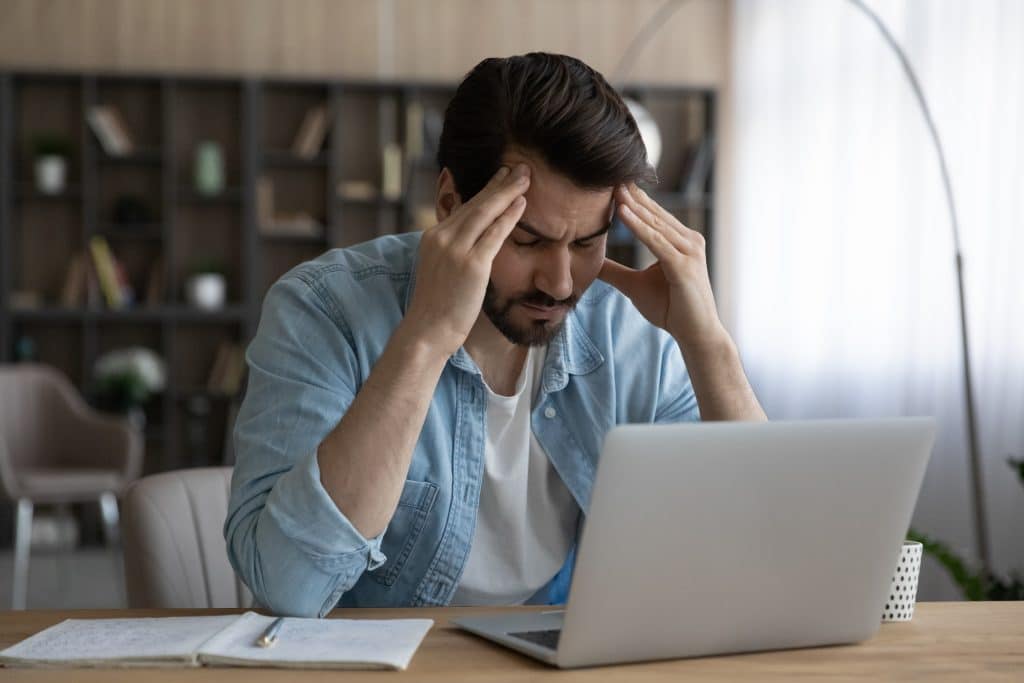 Frustrated man sitting in front of a laptop